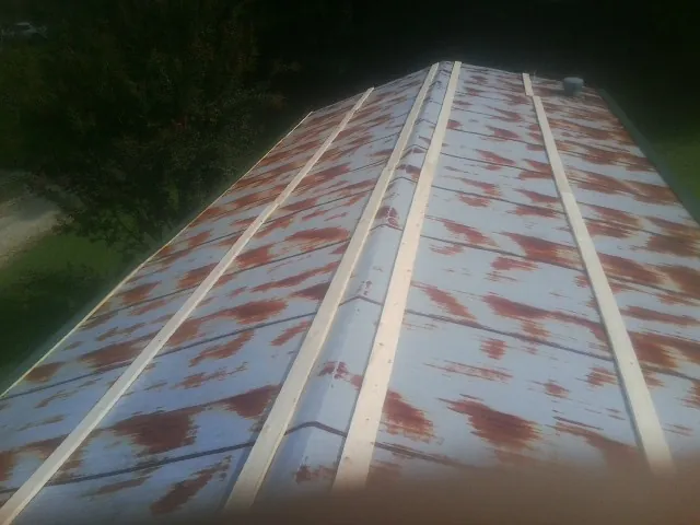 Rusted metal roof panels with new wood purlins before replacement — Storm Damage Roof Repair in Cassatt by Roofing Brothers