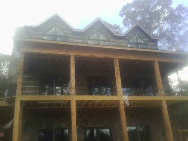 Dormers and porch framing on a large log home under construction — Roof Coating work by our crew in Cassatt