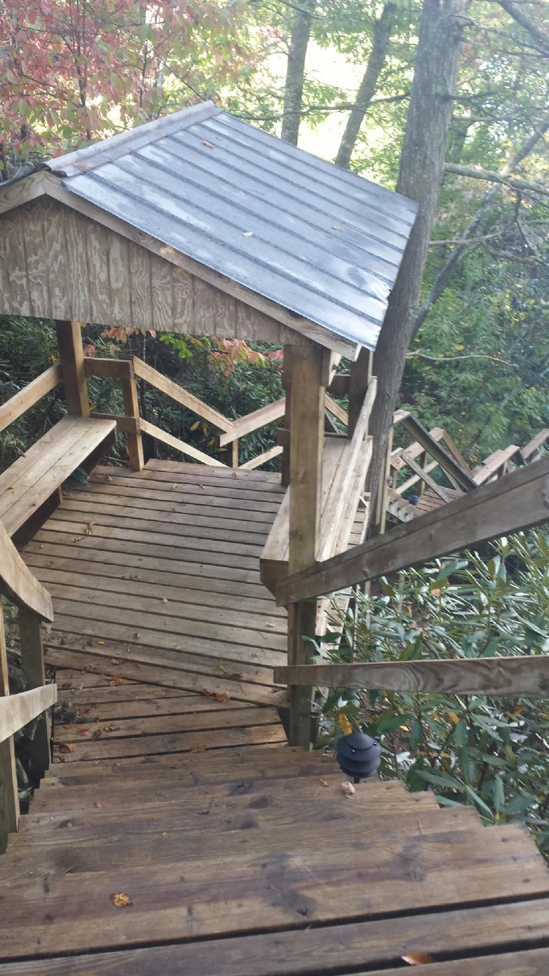 Metal roofed shelter over wooden steps on a wooded walkway — Skylight Repair & Installation work by our crew in Cassatt