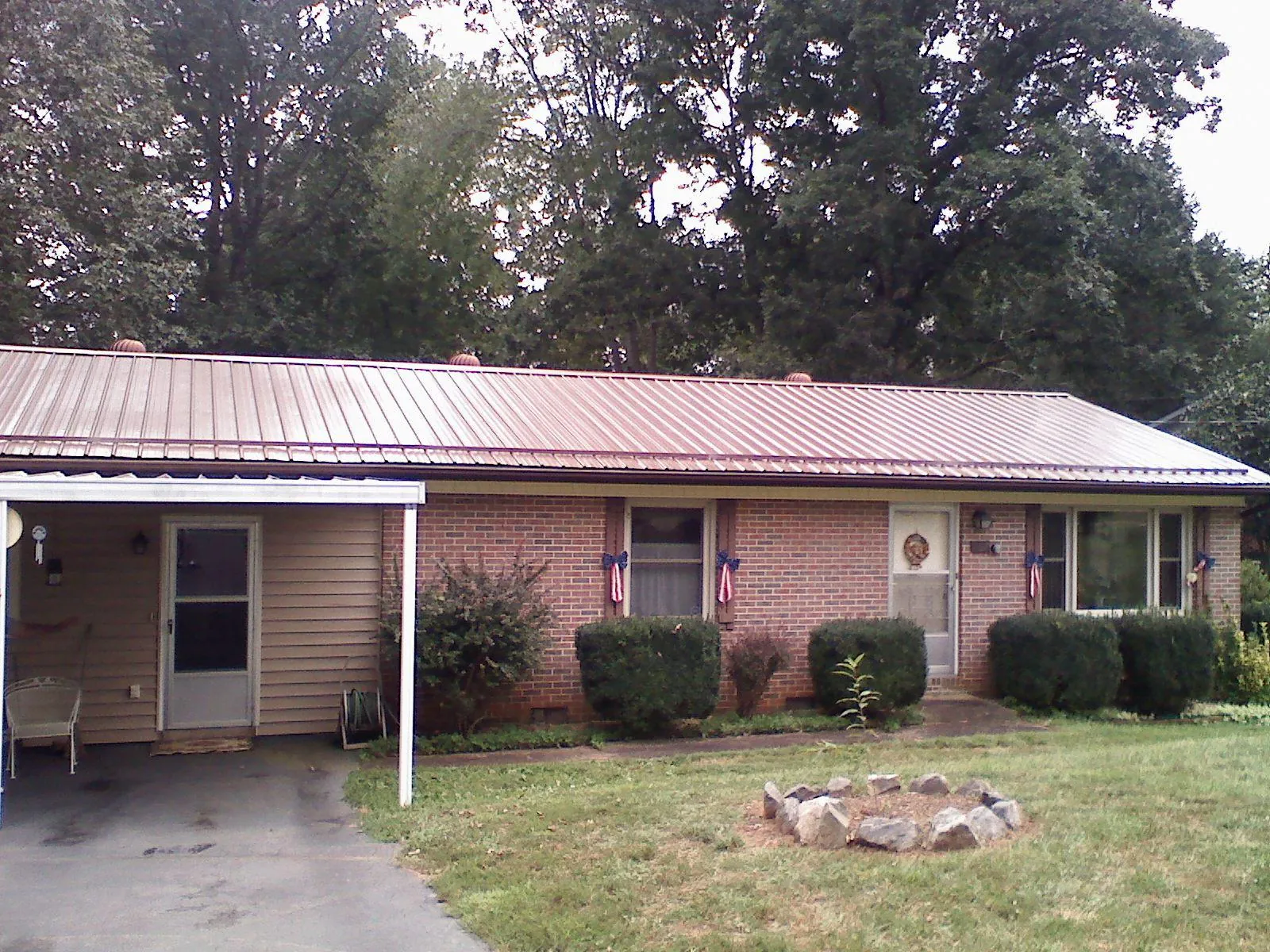 Bronze metal roof and carport on a brick ranch home — Roof Repair work by our crew in Cassatt
